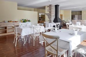 Hotel Txoriene - Arrieta - HBI01298 في Arrieta: غرفة طعام مع طاولات وكراسي بيضاء