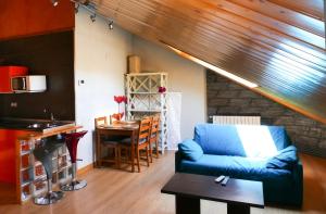 a living room with a blue couch and a table at Apartamentos Rurales Altuzarra in Ezcaray