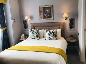 a bedroom with a large bed with yellow and blue pillows at The Alexander - Adults Only in Scarborough