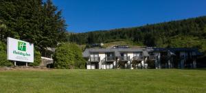 un grand bâtiment avec un panneau devant lui dans l'établissement Holiday Inn Queenstown Frankton Road, an IHG Hotel, à Queenstown