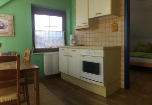 a kitchen with a stove and a table and a window at P43 Apartment in Villach