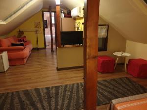 Porto Lima في Limanu: غرفة معيشة مع أريكة وتلفزيون