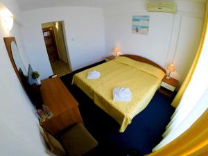 Una habitación con una cama con dos toallas. en Hotel Lotos, en Kiten