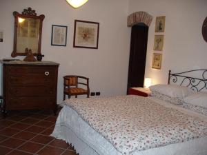1 dormitorio con cama, tocador y espejo en Cascina nel bosco, en Moncucco Torinese