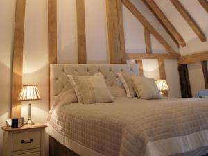 a bedroom with a white bed with two lamps at The Red Cow in Heydon