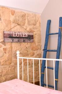 Dormitorio con pared de piedra, cama y cartel en Dimora Mediterranea, en Polignano a Mare