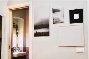 a hallway with a bathroom with pictures on the wall at Dimora Mediterranea in Polignano a Mare