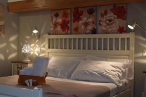 1 dormitorio con 1 cama blanca con flores en la pared en Dimora Mediterranea, en Polignano a Mare