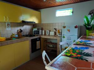 una piccola cucina con tavolo e frigorifero di Dilou Schœlcher a Schœlcher