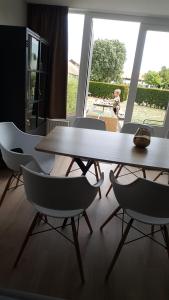 a table and four chairs in a room with a window at Huisje aan zee in Middelkerke