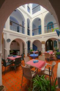 an outdoor patio with tables and chairs in a building at Dar Chefchaouen in Chefchaouene