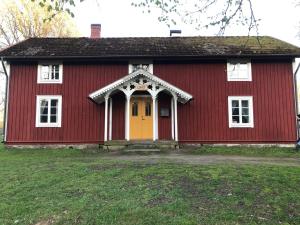 a red and white house with a yellow door at Vandrarhem Lövö in Hillerstorp