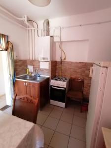 a small kitchen with a sink and a stove at Malomtavi Vendégház in Tapolca