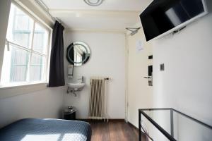 a bedroom with a bed and a sink and a window at Quentin Golden Bear Hotel in Amsterdam