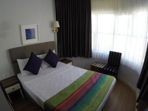 um quarto de hotel com uma cama com um cobertor colorido em Mono Hotel em Antalya