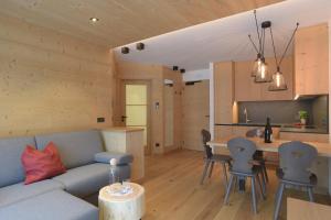 een woonkamer en een keuken met een bank en een tafel bij Appartments Hopfgartner Eurospar in Lutago