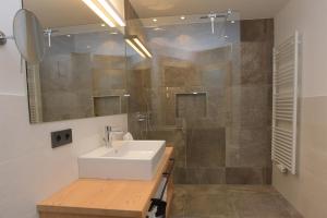 a bathroom with a sink and a shower at Appartments Hopfgartner Eurospar in Lutago