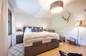 a bedroom with a large bed and a lamp at Alpenrelax Haus Weidmannsheil wohnen im romantischen Forsthaus in Werfen