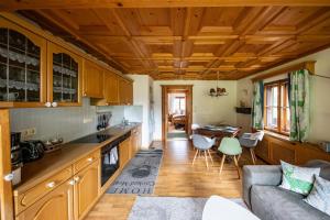 a kitchen and living room with a couch and a table at Alpenrelax Haus Weidmannsheil wohnen im romantischen Forsthaus in Werfen