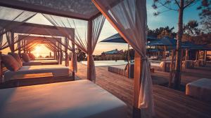 a row of beds on a deck with the sun setting at Charm Nature in Azoia
