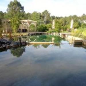 - une vue sur un étang dans un parc dans l'établissement Le Mas de Baume, à Rosières