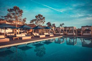 a pool at a hotel with lounge chairs and umbrellas at Charm Nature in Azoia