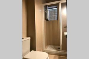 ein Badezimmer mit einem weißen WC und einer Dusche in der Unterkunft 2 baños! Piso grande 100 m2 y Garaje gratis in Madrid