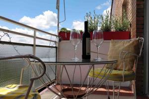 a table with two glasses and a bottle of wine at 2 baños! Piso grande 100 m2 y Garaje gratis in Madrid