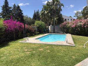 una piscina in un cortile fiorito di Villa Paraisos a Fuengirola
