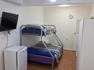 a room with two bunk beds and a tv at The Jewel of the Bay in Smoky Bay