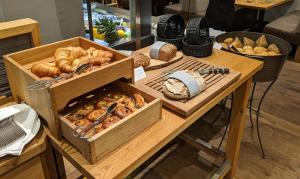 a wooden table topped with a variety of pastries at Hotel Schmachtendorf in Oberhausen