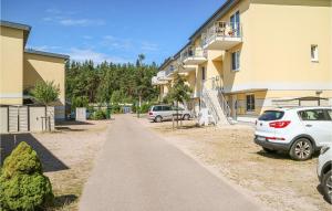 a sidewalk in front of a building with parked cars at Lovely Apartment In Graal-Müritz in Graal-Müritz
