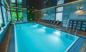 a large swimming pool with blue water in a building at Medical Wellness & SPA Werona in Duszniki Zdrój