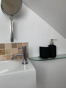 La salle de bains est pourvue d'un lavabo et d'un miroir sur un comptoir. dans l'établissement No11, à Lewes