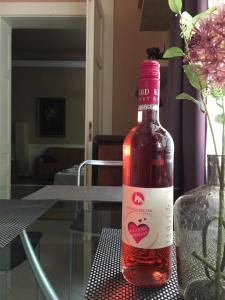 シオーフォクにあるNosztalgia apartmanのワイン1本(テーブルと花瓶の上に置く)