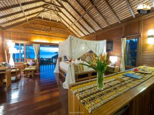 a bedroom with a bed with a vase of flowers on a counter at Bunaken Oasis Dive Resort and Spa in Bunaken