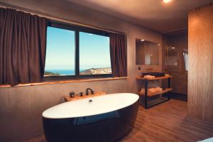 a bathroom with a tub and a large window at Charm Nature in Azoia