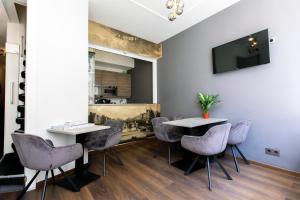 a room with two tables and chairs and a television at Quentin Golden Bear Hotel in Amsterdam