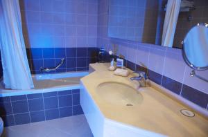 a blue tiled bathroom with a sink and a tub at Grand Bellevue Hotel Apartment Dubai in Dubai