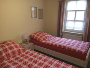 2 Betten in einem Schlafzimmer mit einer karierten Decke in der Unterkunft Klaassen- Ferienhaus Up Warf in Emden