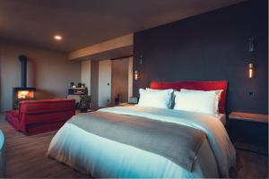 a bedroom with a large bed and a red chair at Charm Nature in Azoia