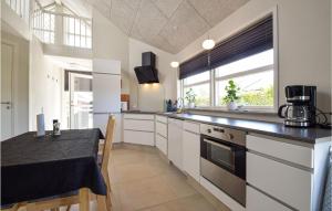 kuchnia z białymi szafkami i czarnym blatem w obiekcie Awesome Home In Kerteminde With Wifi w mieście Kerteminde
