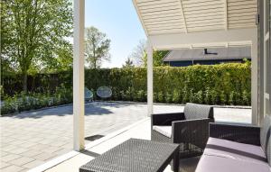 une terrasse couverte avec des chaises et des tables. dans l'établissement Awesome Home In Kerteminde With Wifi, à Kerteminde