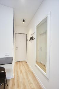 um corredor com um espelho grande e uma porta em City Rooms Apartments em Odessa