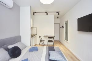 um quarto com uma cama e uma mesa com uma televisão em City Rooms Apartments em Odessa