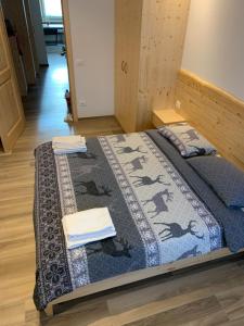 a bed in a room with a quilt on it at Ciasa De Rosa in Pozza di Fassa
