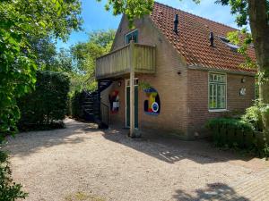 - une vue sur l'extérieur d'une maison avec une terrasse couverte dans l'établissement De Windroos | Atelier Aan Zee, à Groet