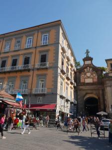 un grupo de personas caminando en una calle frente a un edificio en Piazza Dante 22 Apartment, en Nápoles