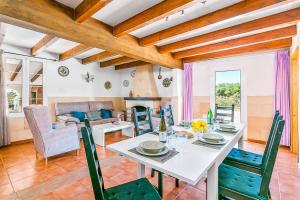 een eetkamer met een witte tafel en groene stoelen bij Villa Menorca Verde 1 by Mauter Villas in Ciutadella