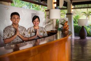 Um homem e uma mulher estão a rezar num bar. em Bunaken Oasis Dive Resort and Spa em Bunaken